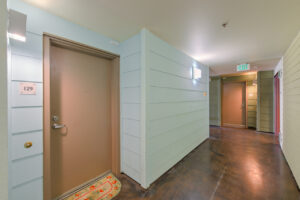 Interior Hallway, unit 129, wood panel walls, concrete flooring.