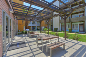 Exterior Courtyard, Outdoor dining area, community grill, picnic tables, meticulous landscaping.